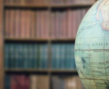 A globe displayed in a library, suggesting world geography and global time zones.