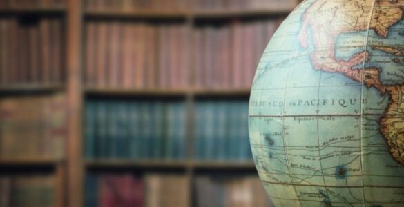 A globe displayed in a library, suggesting world geography and global time zones.