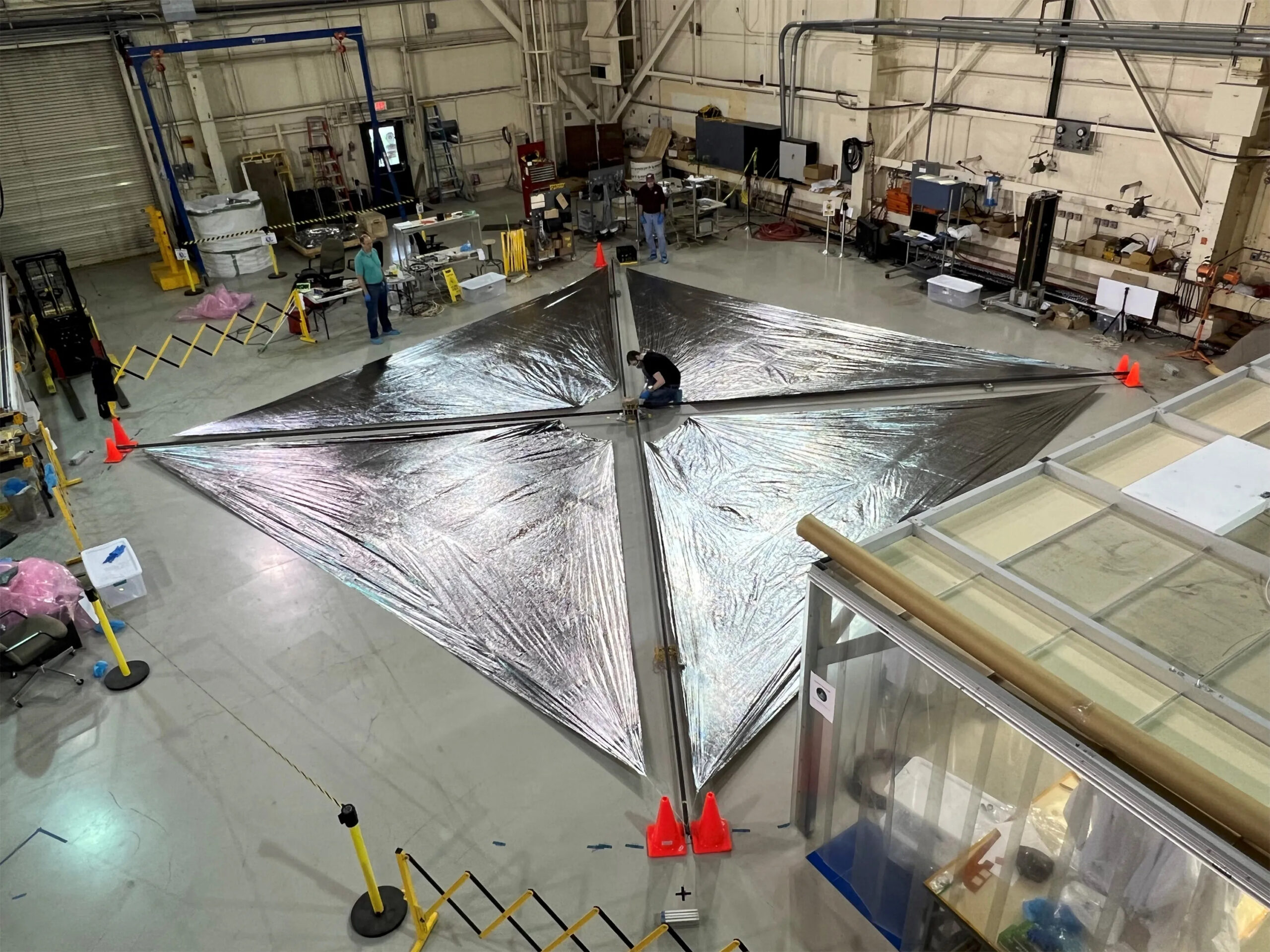 Engineers test deployment of a large square solar sail at NASA Langley Research Center.