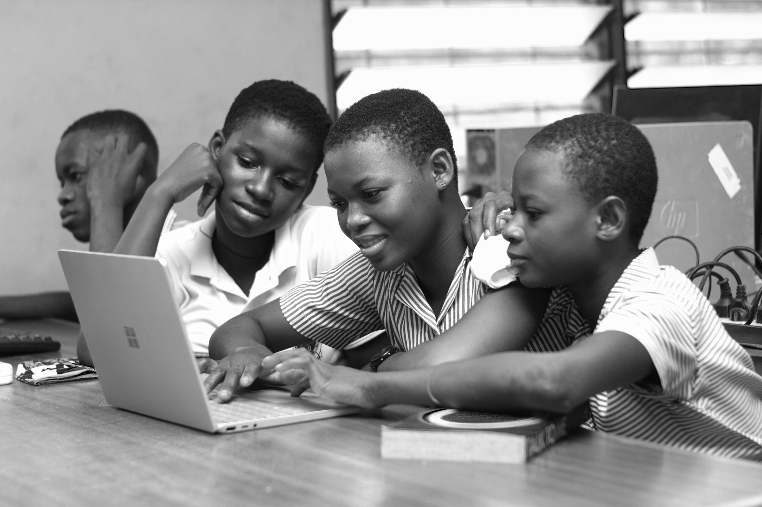 Students gathered around a laptop while studying together