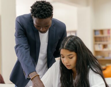 A college student and advisor reviewing course questions at a desk before professor office hours