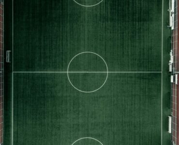 An aerial view of a soccer field showing the full pitch layout.