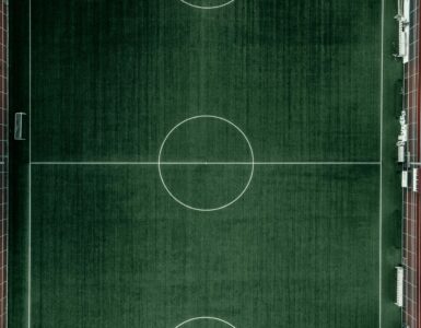 An aerial view of a soccer field showing the full pitch layout.