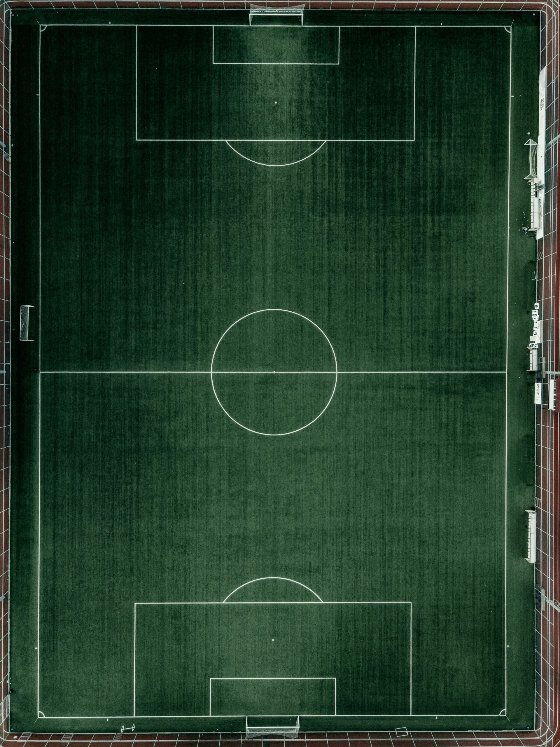An aerial view of a soccer field showing the full pitch layout.