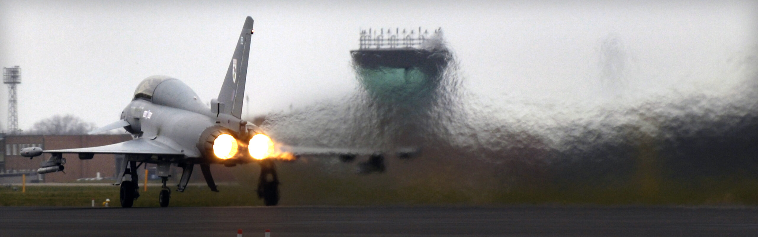 An aircraft taking off over a runway with visible heat haze behind it