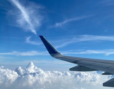 Airplane wing above clouds during a clear high-altitude flight