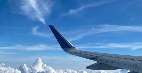 Airplane wing above clouds during a clear high-altitude flight