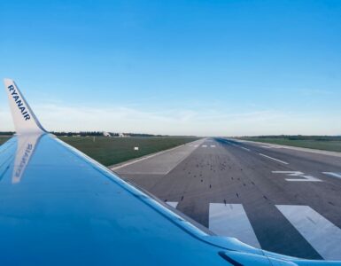 View from an airplane window showing a wing and runway before a flight involving cabin pressure changes