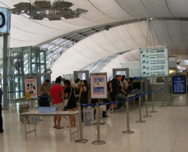 Passengers placing bags on an airport security X-ray conveyor