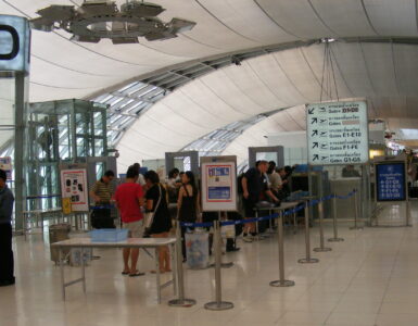 Passengers placing bags on an airport security X-ray conveyor