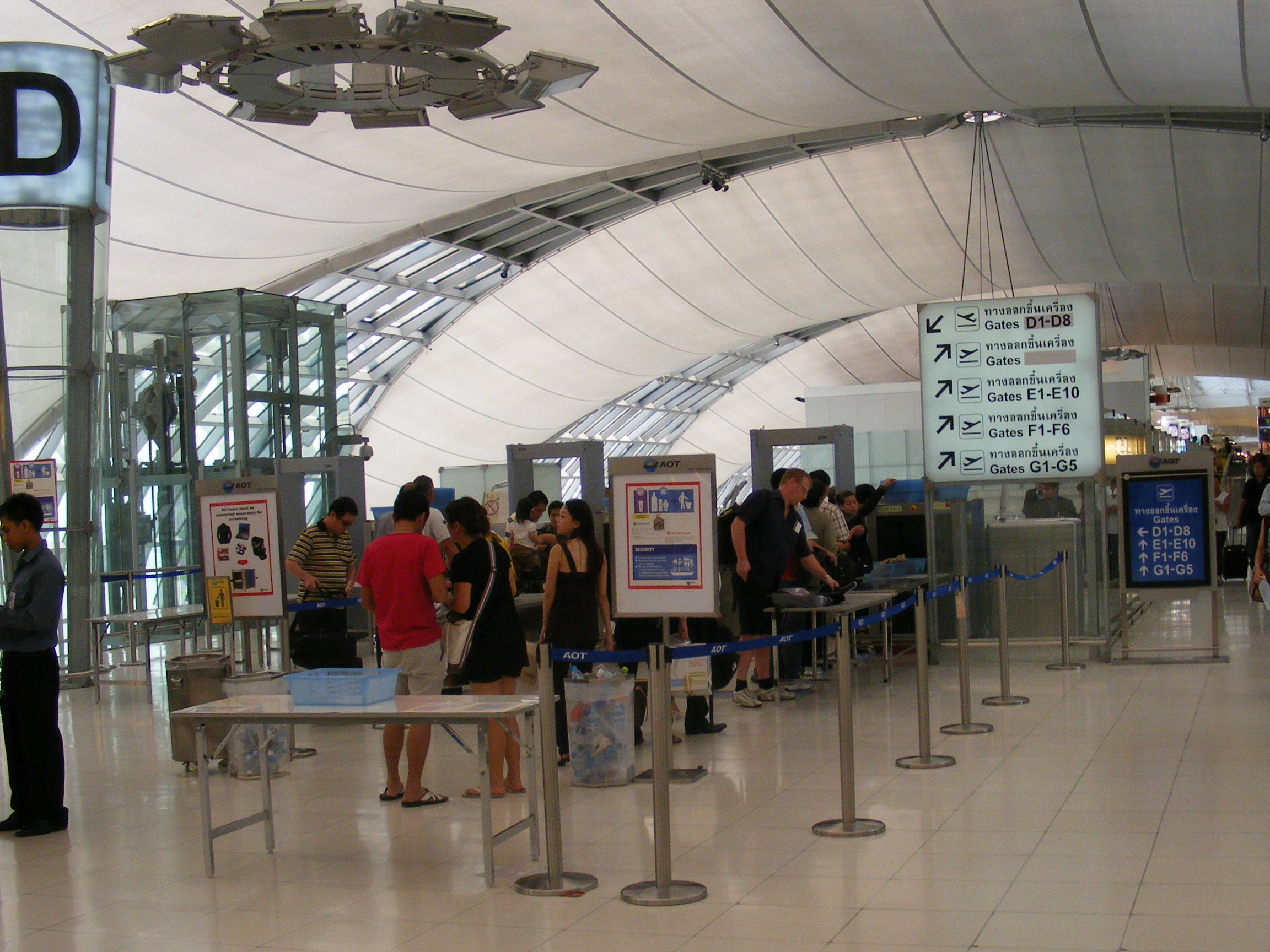 Passengers placing bags on an airport security X-ray conveyor