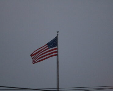 An American flag waving outdoors against a clear sky