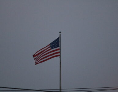 An American flag waving outdoors against a clear sky