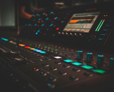 Audio mixing console with glowing controls in a recording studio
