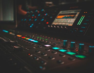 Audio mixing console with glowing controls in a recording studio