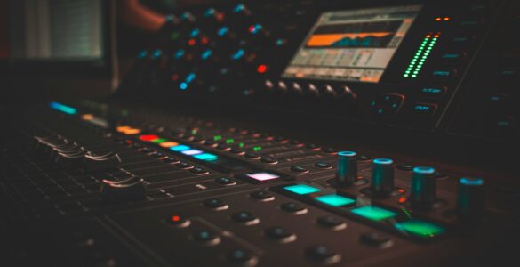 Audio mixing console with glowing controls in a recording studio