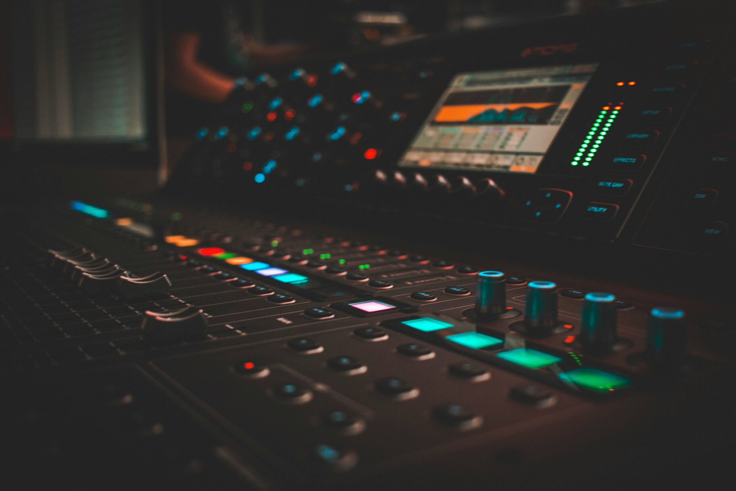 Audio mixing console with glowing controls in a recording studio