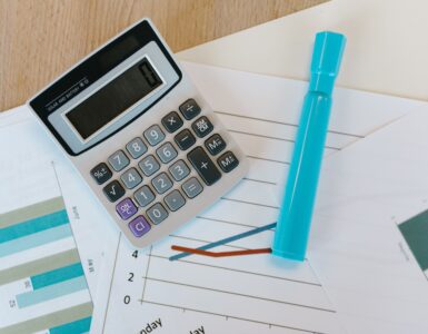 Calculator on printed charts used to compare statistics and probabilities.