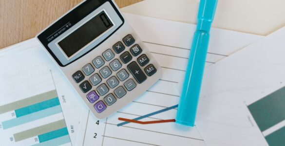A calculator on printed statistics charts for comparing grouped data and overall rates.