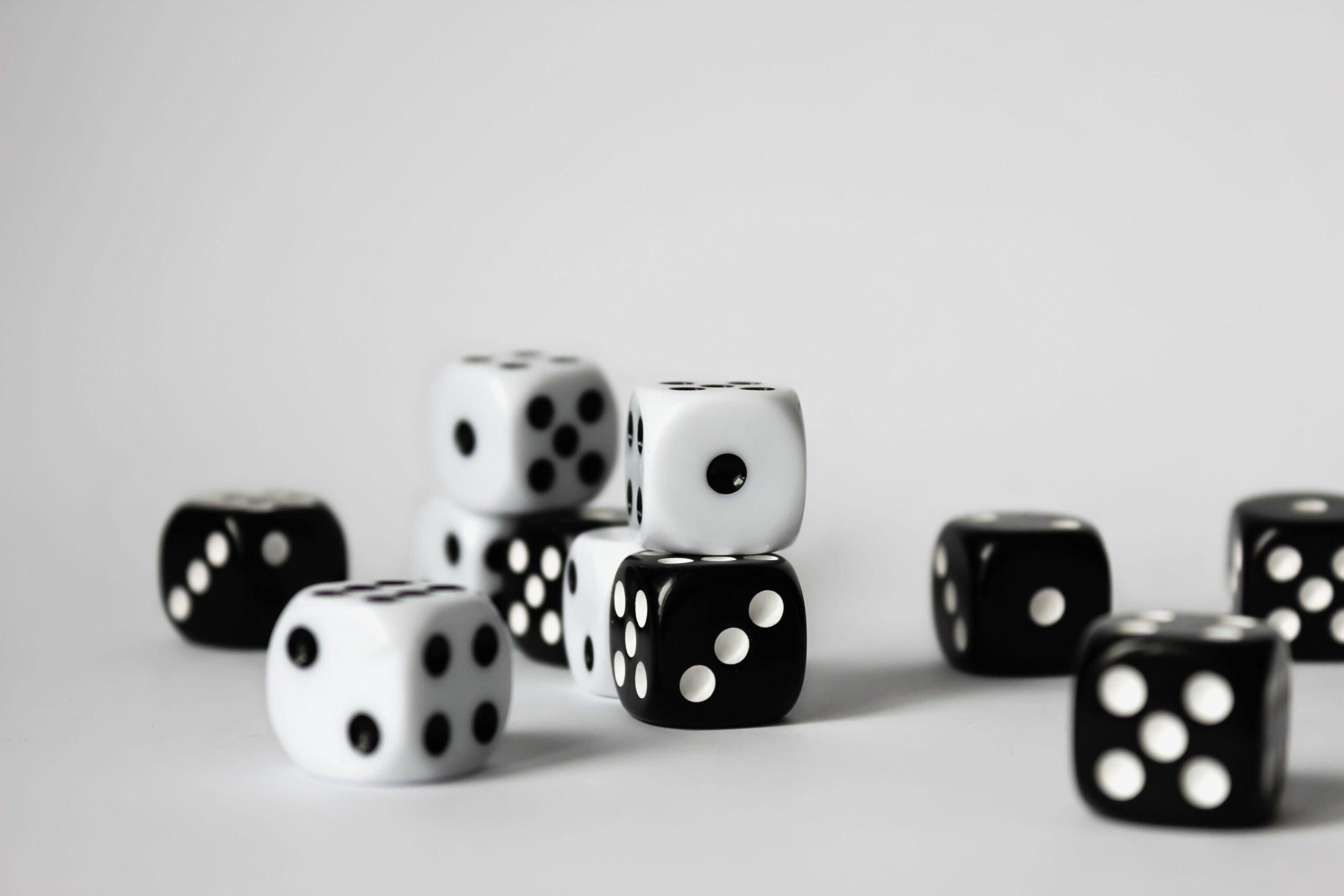 Black and white dice on a plain surface representing chance, risk, and possible outcomes.