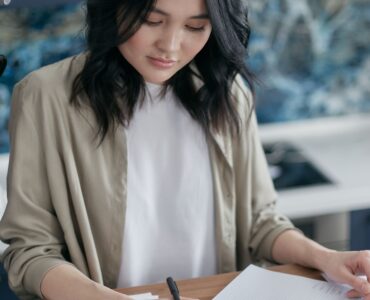 A person uses a calculator while reviewing financial documents.