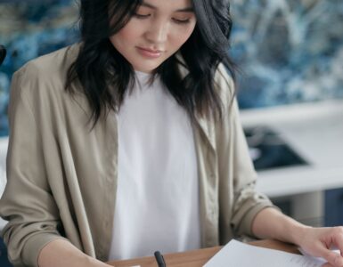 A person uses a calculator while reviewing financial documents.