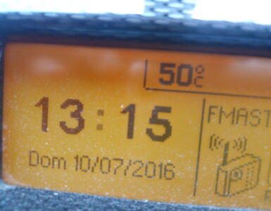 A car temperature display showing hot weather conditions inside a vehicle