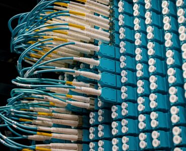 Blue fiber optic cables connected to a data center patch panel