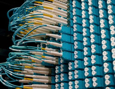 Blue fiber optic cables connected to a data center patch panel