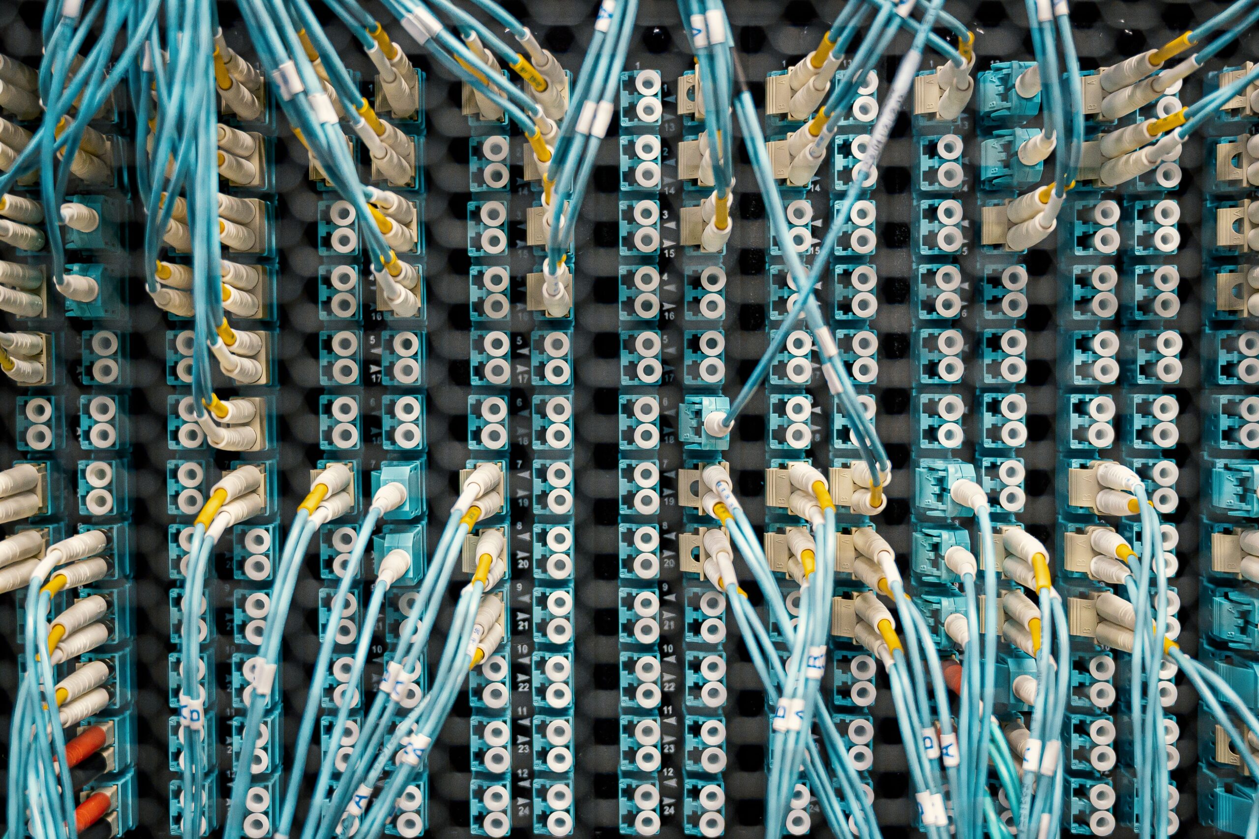 Fiber optic cables connected to a network panel, representing how internet traffic moves through different networks