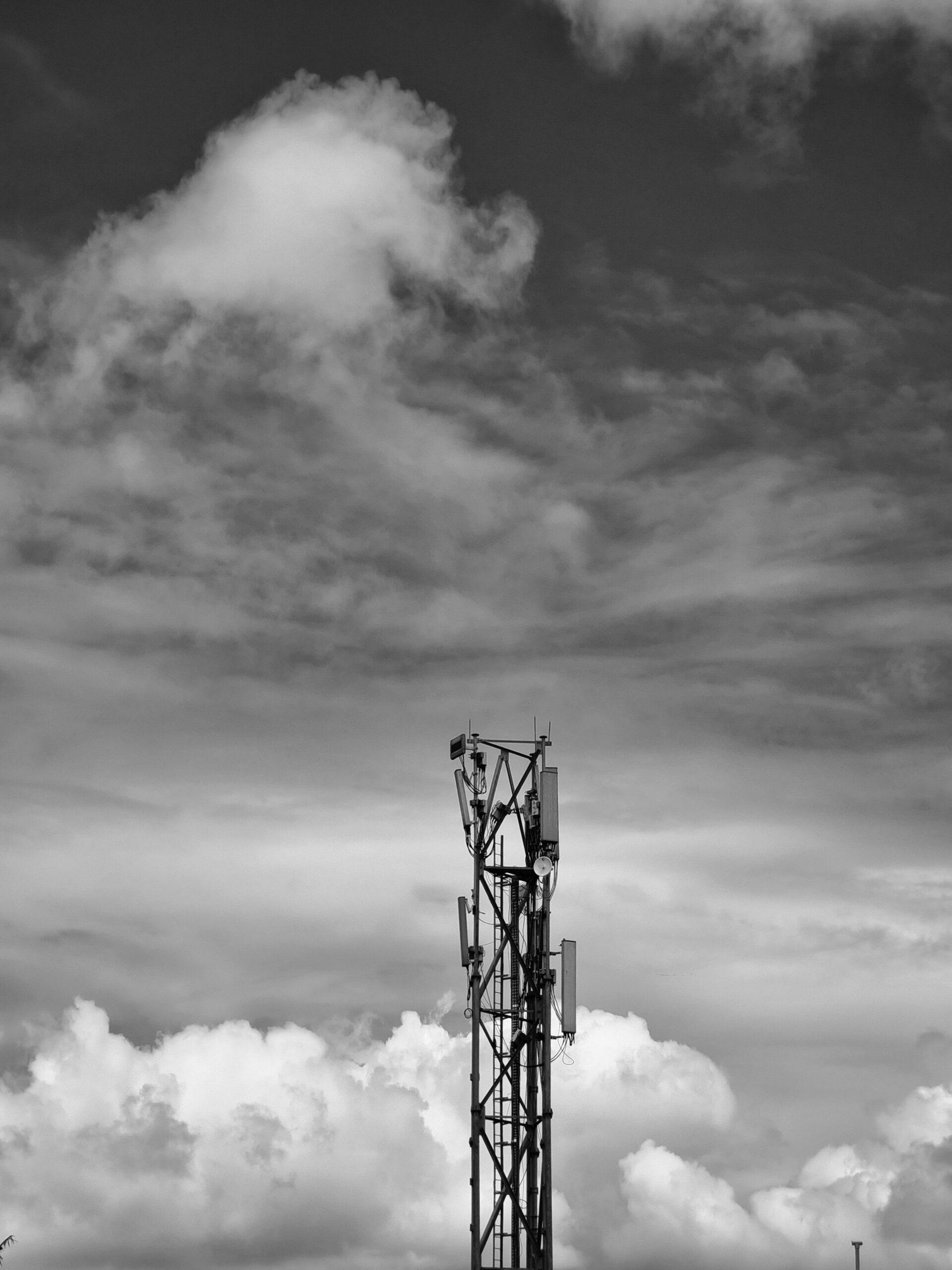 A cell tower rising into cloudy sky as part of a mobile network