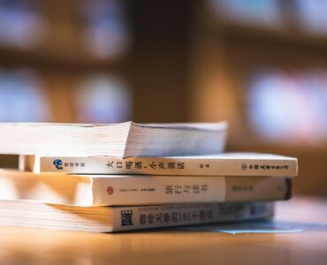 Chinese language books on a study table for learning Mandarin grammar and question particles.