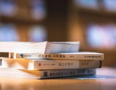 Chinese language books on a study table for learning Mandarin grammar and question particles.