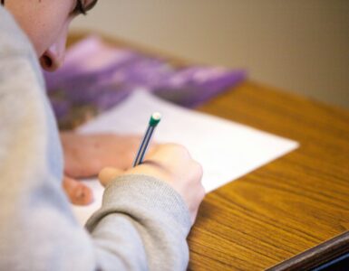 A student writes during a college credit-by-exam test for possible prior learning credit