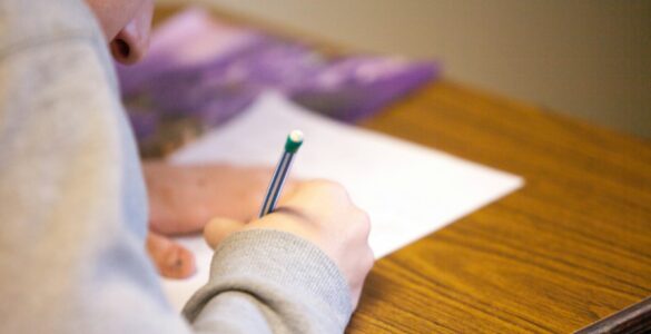 A student writes during a college credit-by-exam test for possible prior learning credit