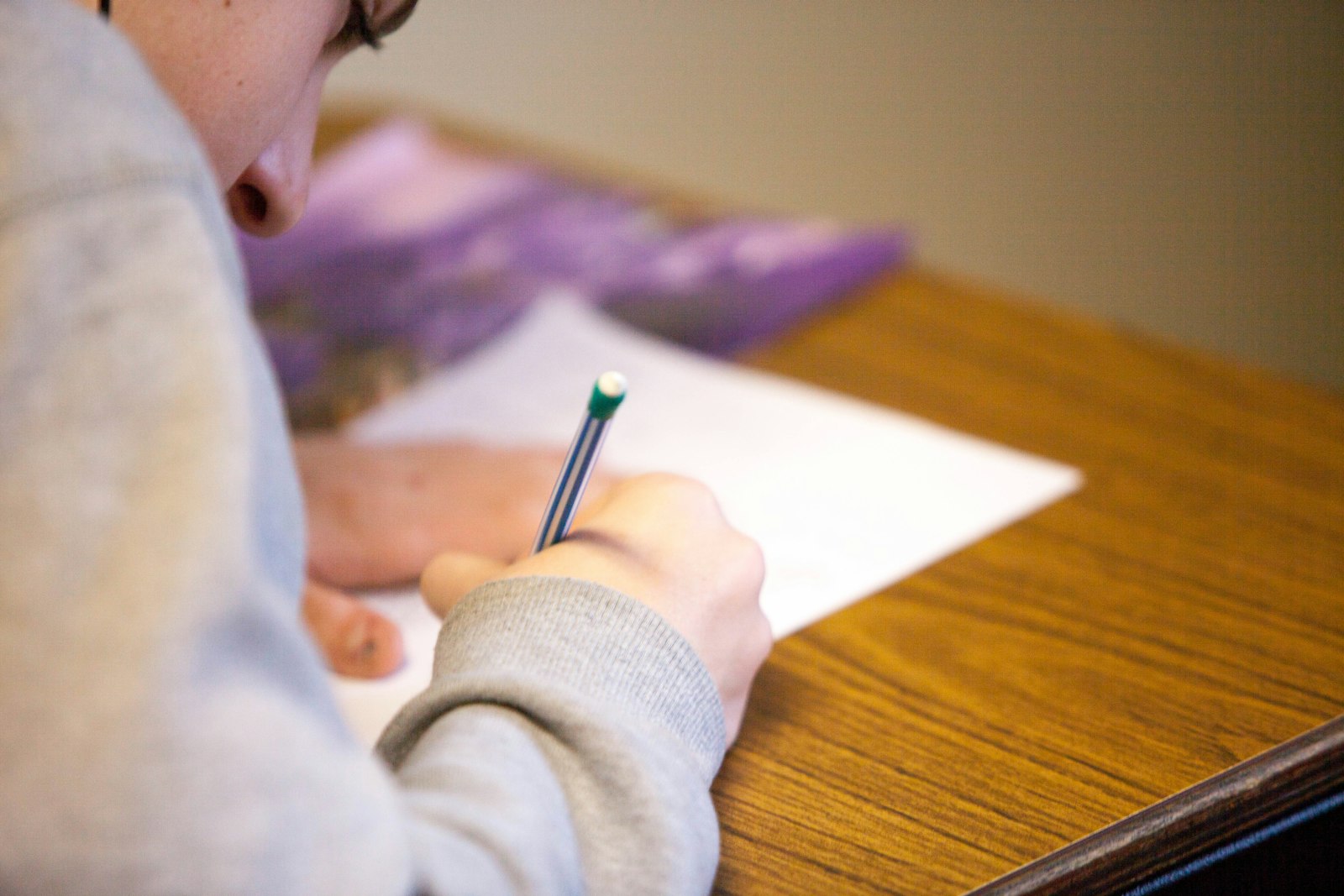 A student writes with a pencil during an exam.