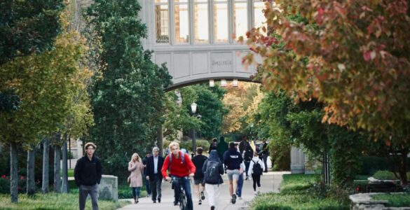 Students walking and biking on a college campus path