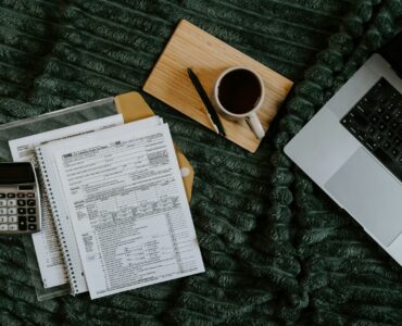 A laptop and paperwork used to review a college health insurance waiver before the deadline