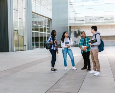 College students talking outside a campus building while planning first-semester courses