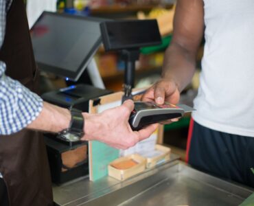 A customer uses a payment card at a checkout terminal.