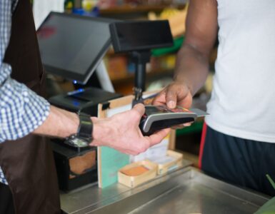 A customer uses a payment card at a checkout terminal.