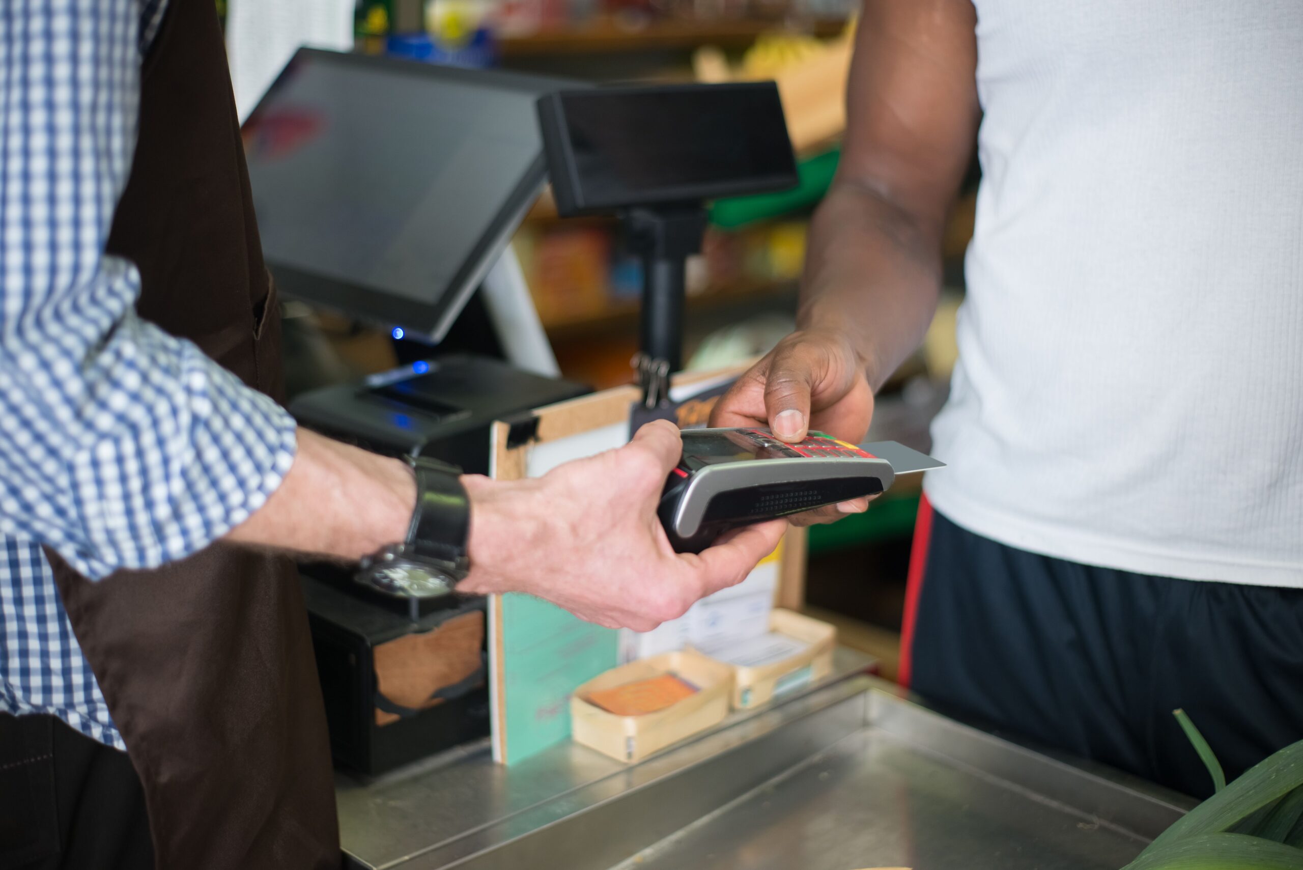 A customer uses a payment card at a checkout terminal.