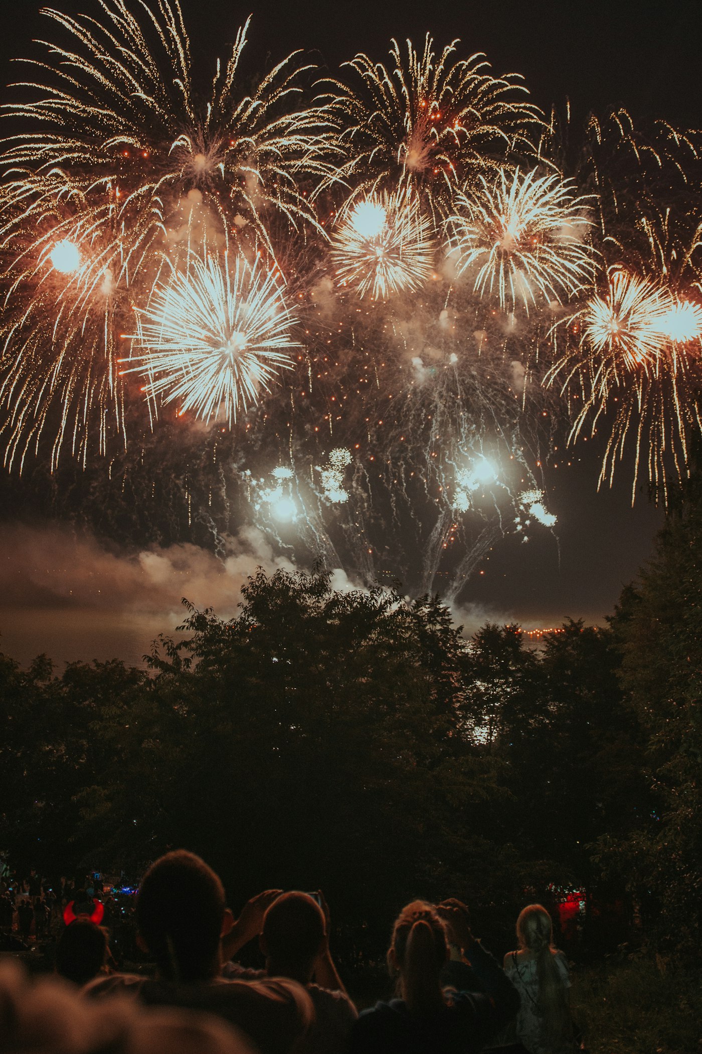 People watching a large fireworks display from a distance