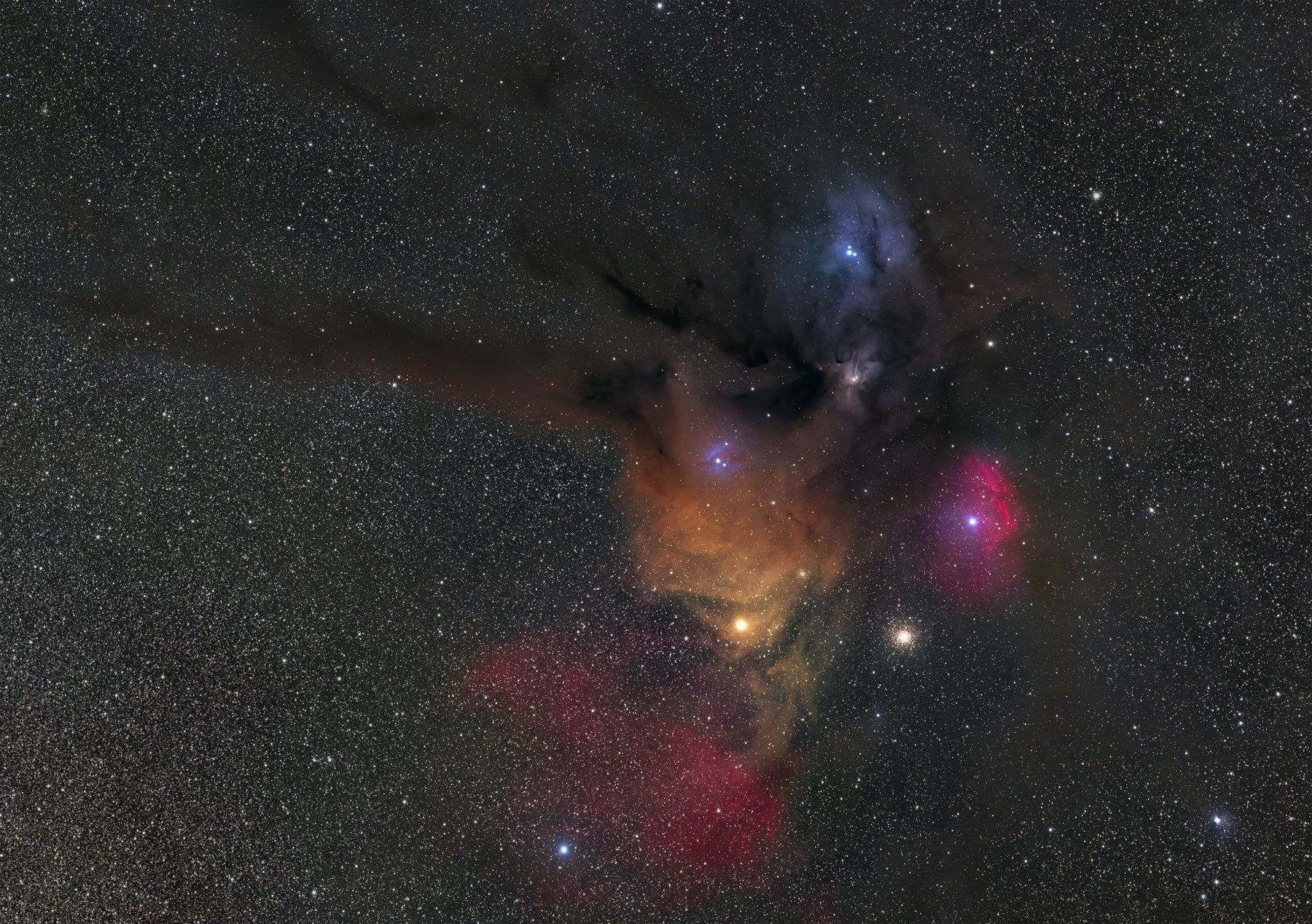 A dense field of stars and colorful nebulae visible in a dark sky.