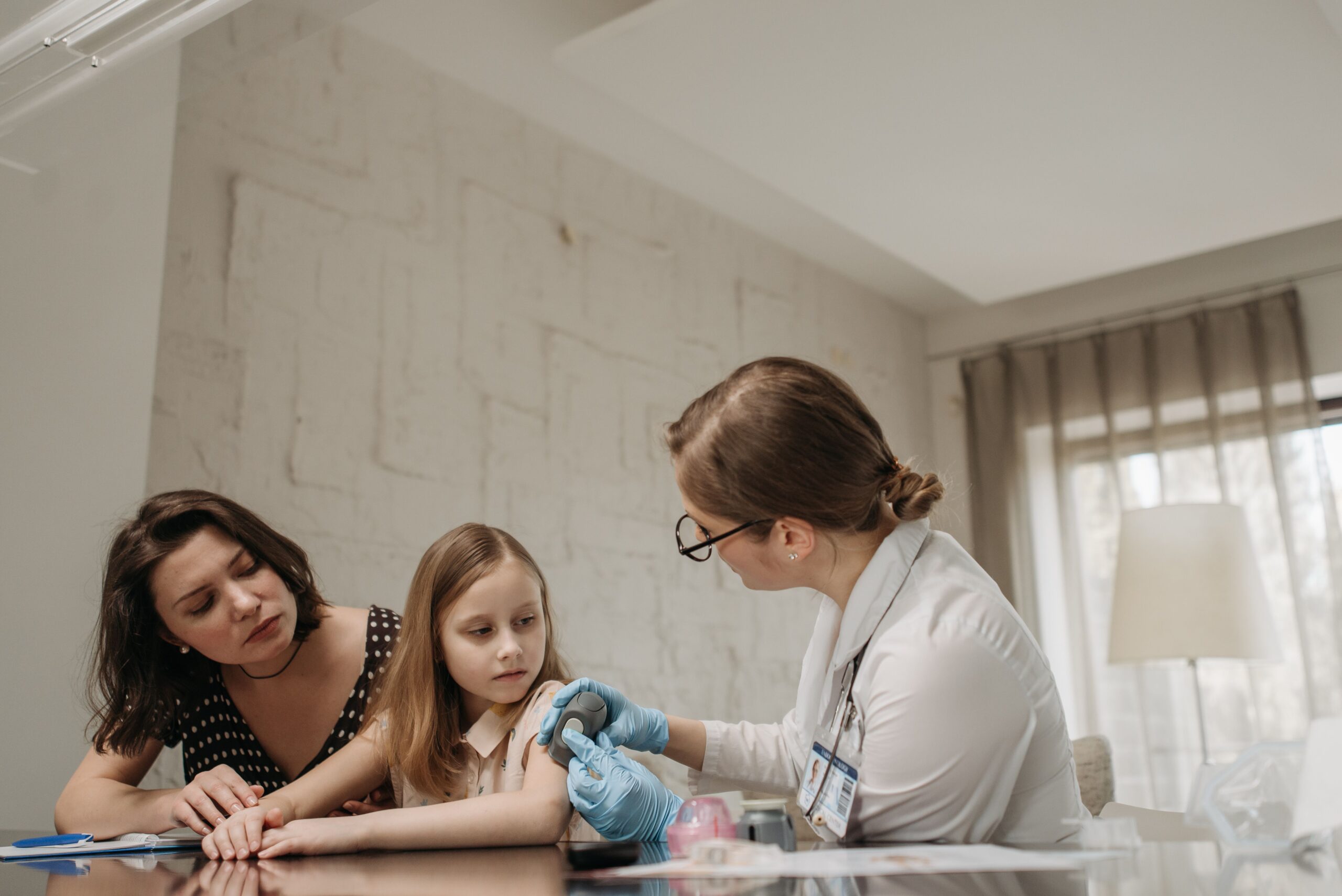 A doctor prepares to vaccinate a child while a parent watches