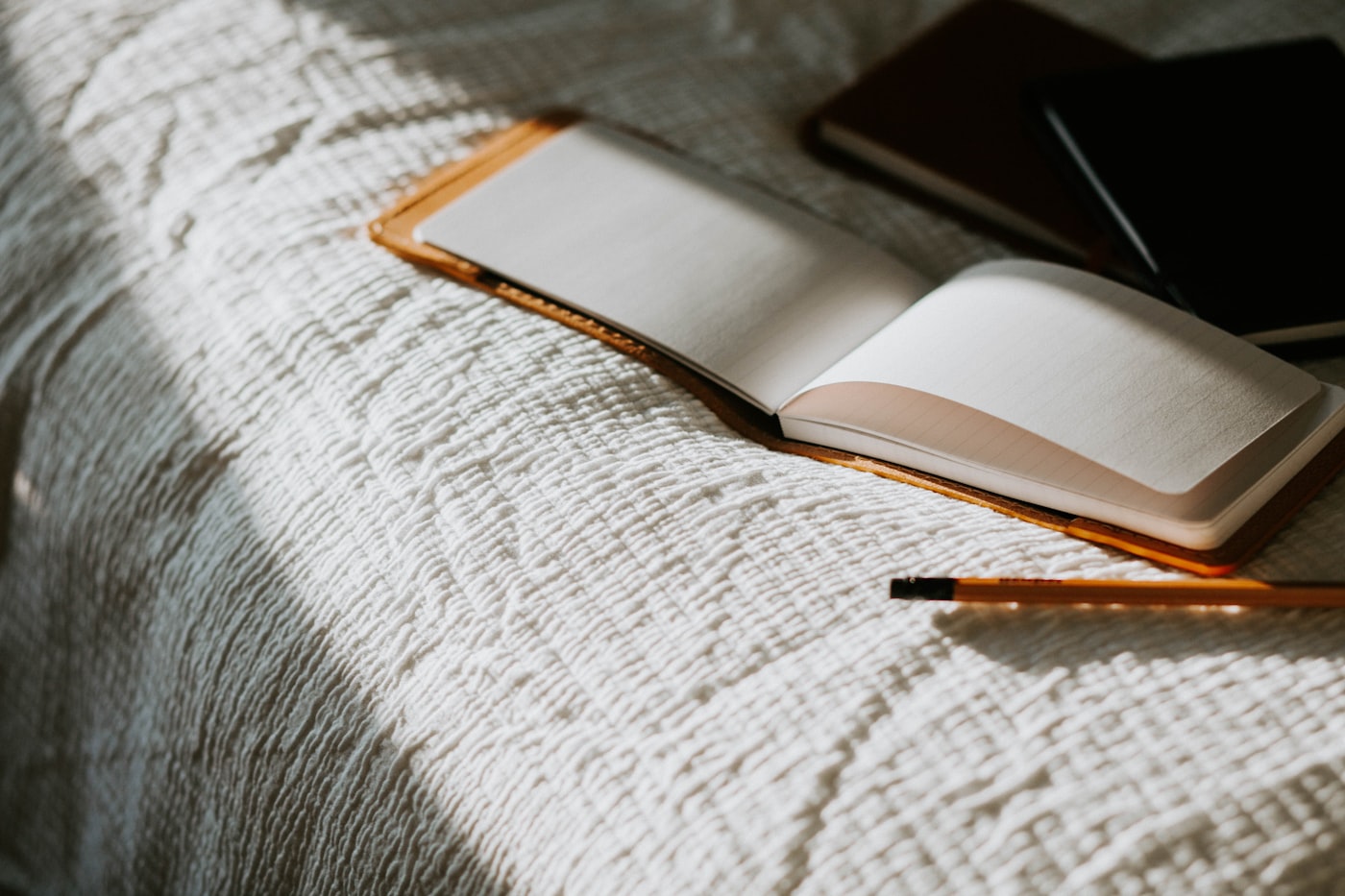 An open notebook on a bed for writing down remembered dreams after waking.