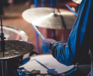 A drummer holding sticks over a drum kit during a live performance