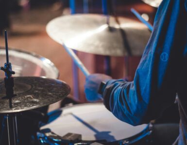 A drummer holding sticks over a drum kit during a live performance
