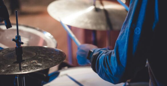 A drummer holding sticks over a drum kit during a live performance