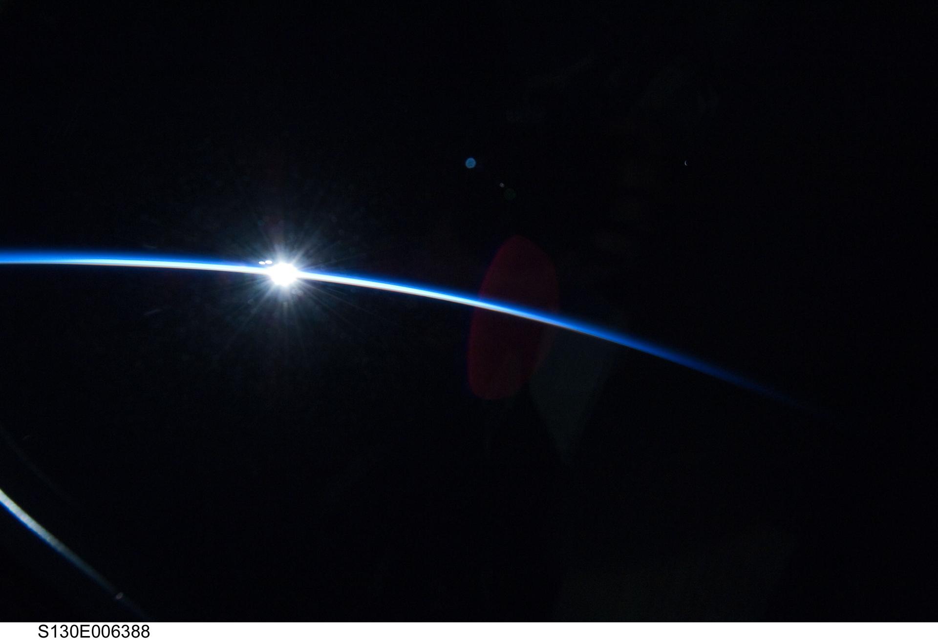 Sunrise over Earth's curved horizon photographed from orbit